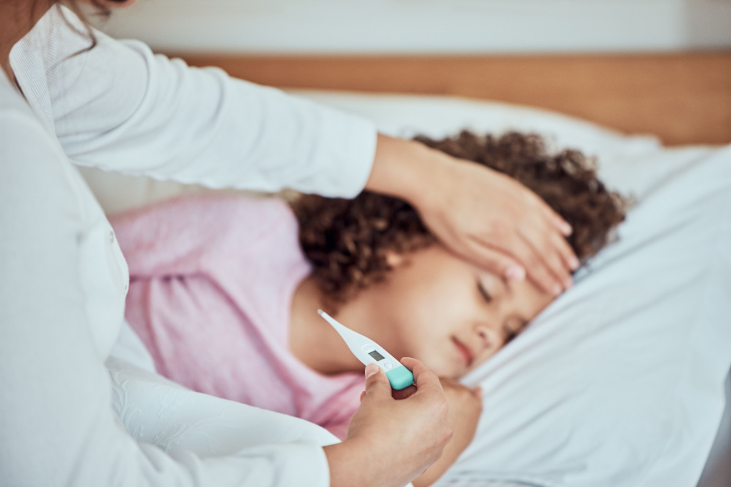 A small girl getting her temperature taken