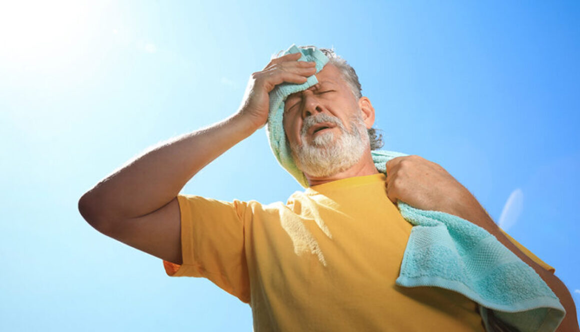 A man wiping his forehead from heat exhaustion