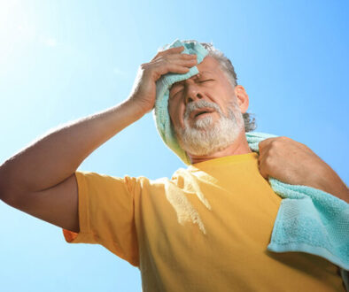 A man wiping his forehead from heat exhaustion