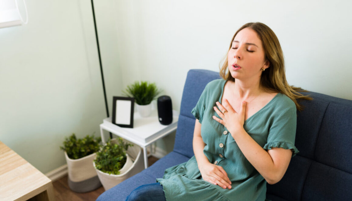 A woman holds her chest as she strains to breathe.