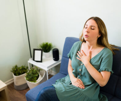 A woman holds her chest as she strains to breathe.