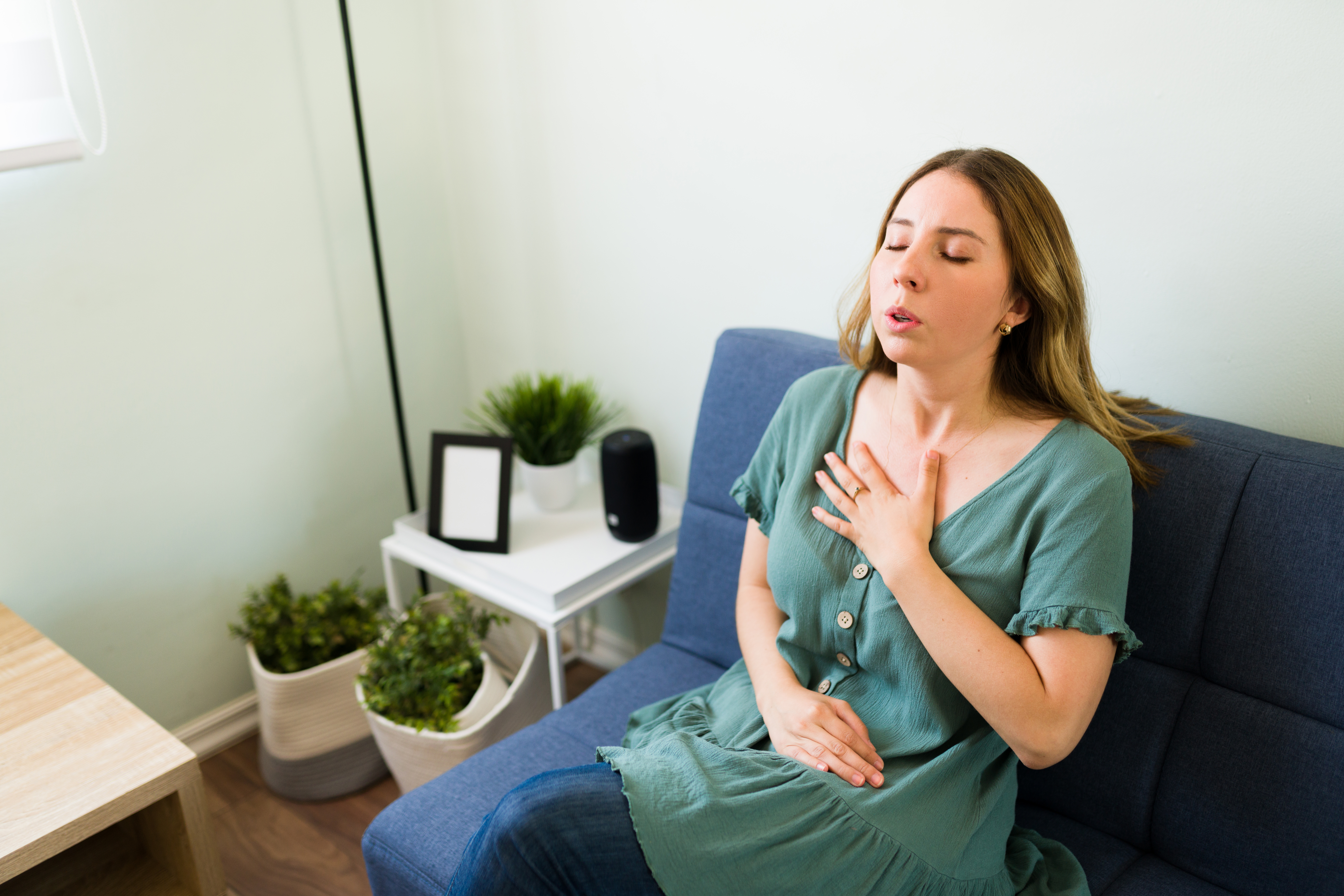 A woman holds her chest as she strains to breathe.